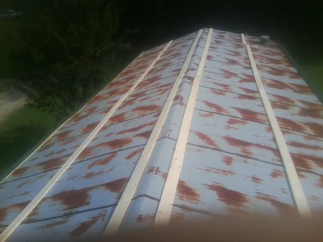 Rusted metal roof panels with new wood purlins before replacement — Storm Damage Roof Repair in Minotola by Roofing Brothers
